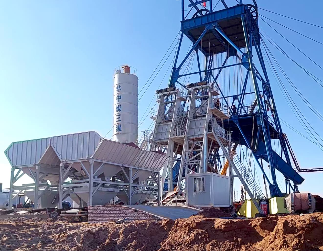 TIANYU skip-hoist batching plant supplying a mine shaft headframe, with cement silo and aggregate batcher line
